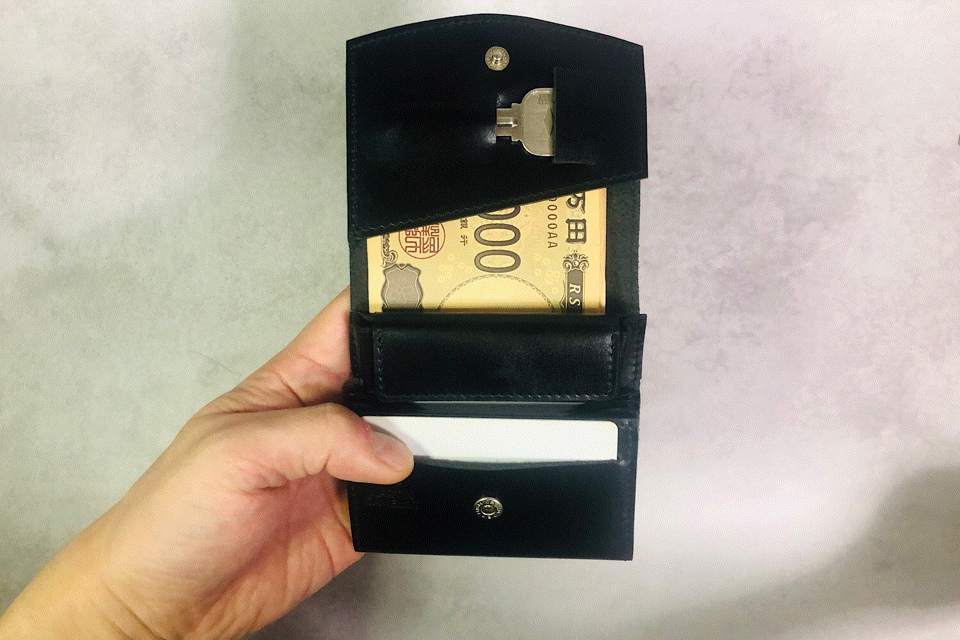 MC-bifoldwallet。蔵前の革職人が製作した国産牛革の薄いコンパクト二つ折り財布。ブラック。カードホルダーからカードを取り出しているGIFアニメーション。