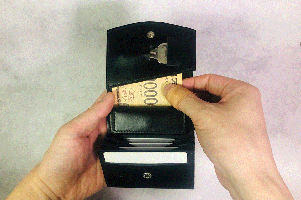 MC-bifoldwallet。蔵前の革職人が製作した国産牛革の薄いコンパクト二つ折り財布。ブラック。紙幣を取り出しているGIFアニメーション。