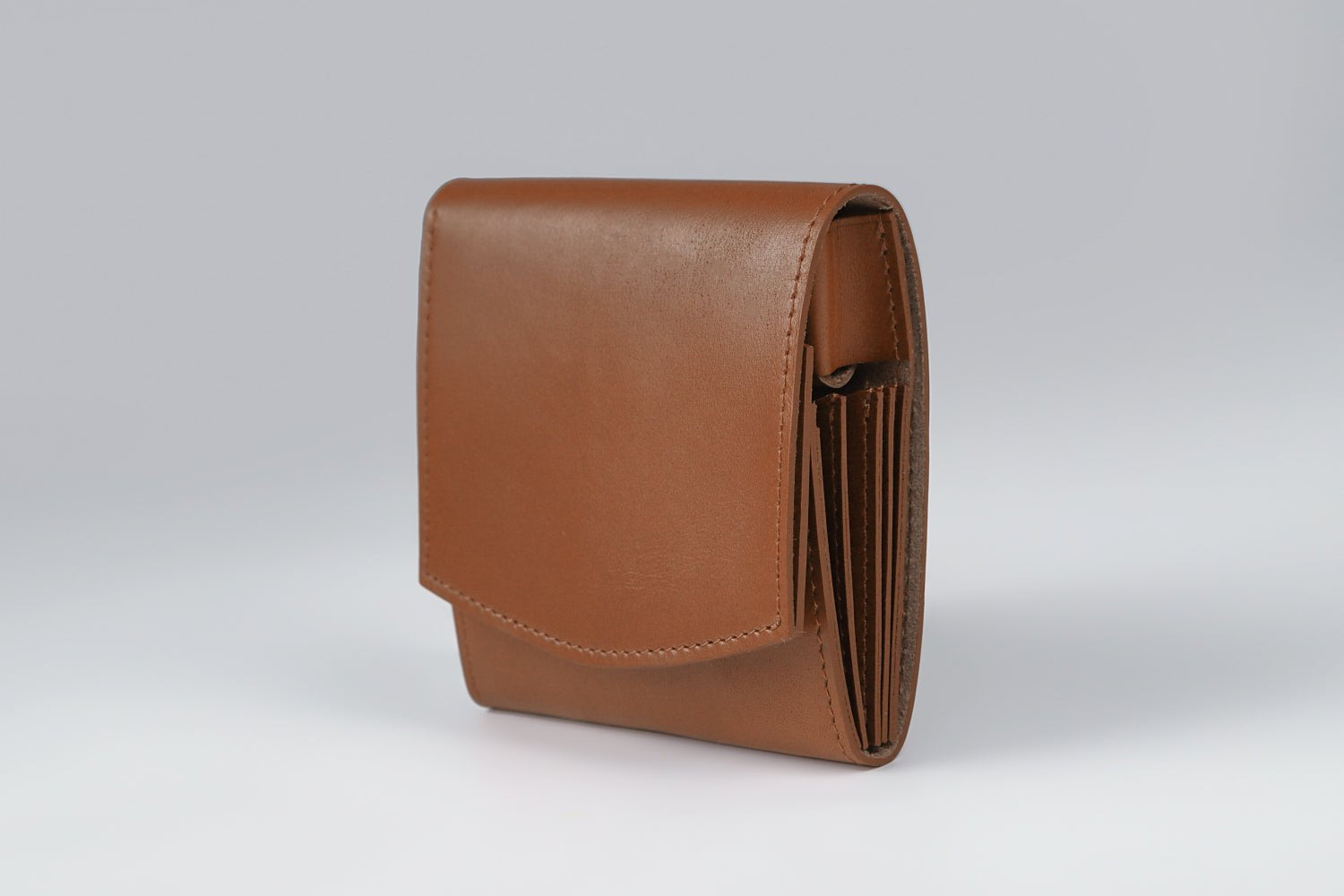 MC-bifoldwallet。蔵前の革職人が製作した国産牛革の薄いコンパクト二つ折り財布。キャメル。斜めのイメージ。