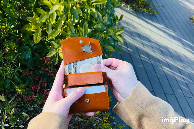 MC-bifoldwallet。蔵前の革職人が製作した国産牛革の蛇腹式コンパクト二つ折り財布。キャメル。紙幣を取り出しているGIFアニメーション。