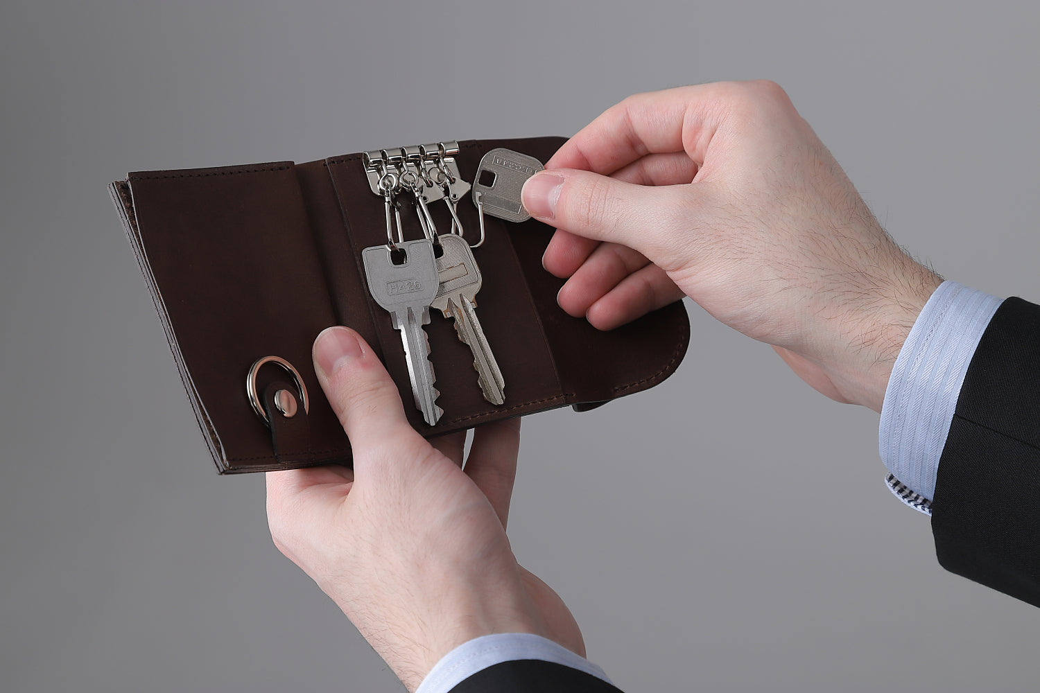 MC-keyminimal。蔵前の革職人が製作した国産牛革のキーケース一体型ミニマル財布。ダークブラウン。キーケースから鍵を取り出しているイメージ。