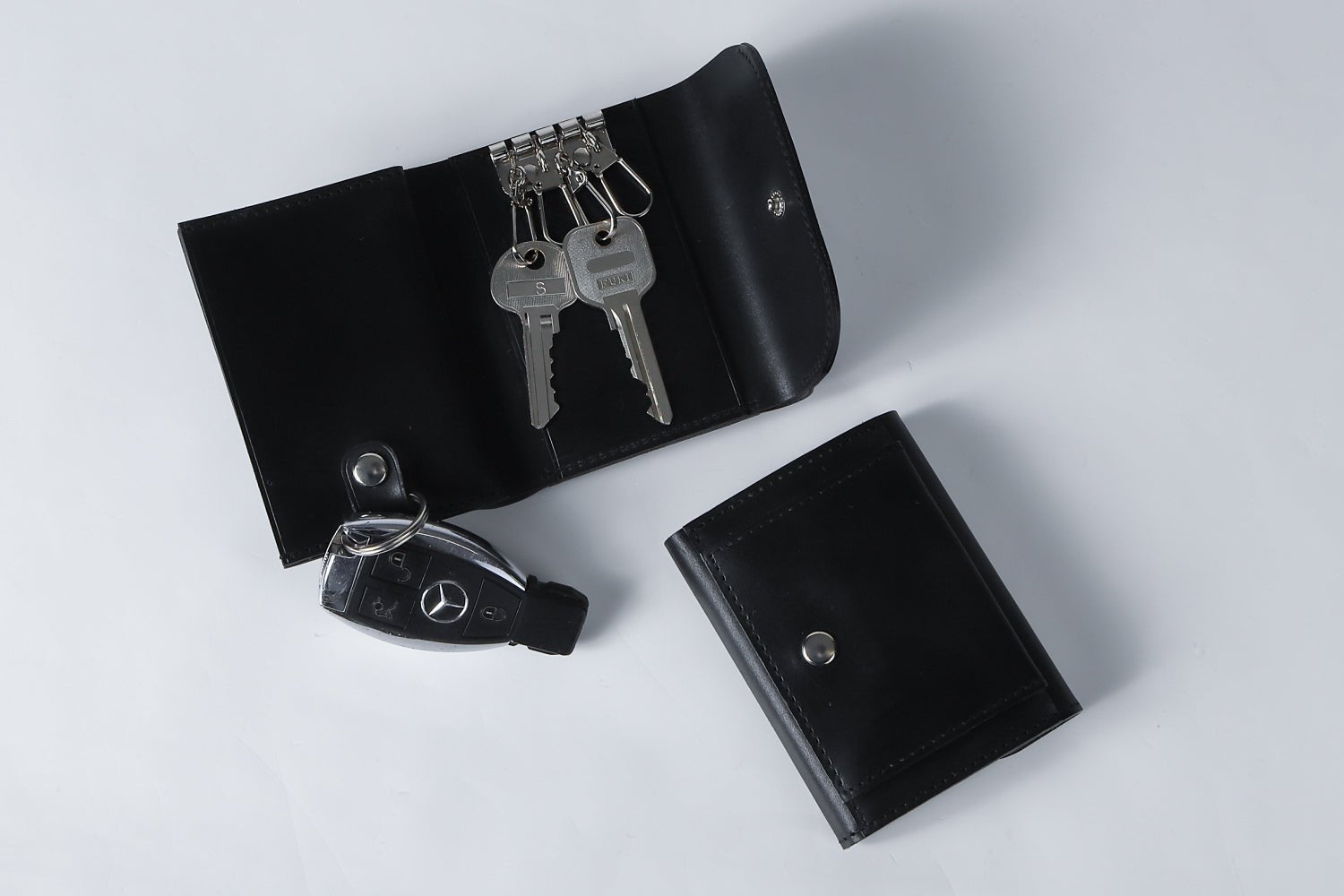 MC-keywallet。蔵前の革職人が製作した国産牛革のキーケース一体型ミニ財布。ブラック。コインBOXが閉じた状態と鍵、スマートキーの収納イメージ。