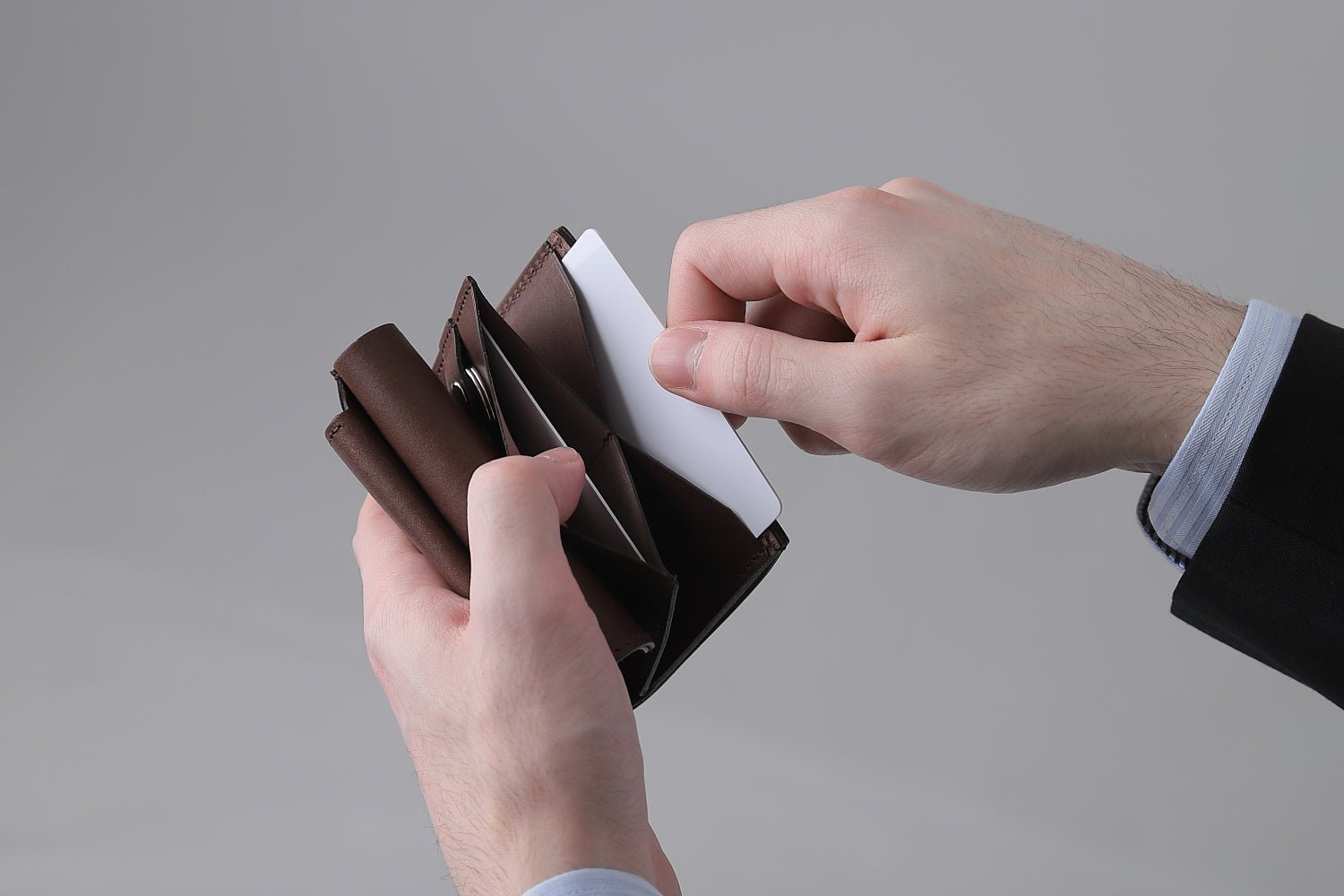 MC-keywallet。蔵前の革職人が製作した国産牛革のキーケース一体型ミニ財布。ダークブラウン。カードホルダーからカードを取り出しているイメージ。