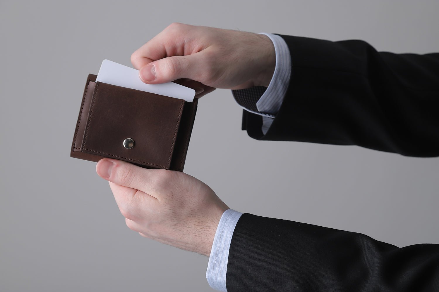 MC-keywallet。蔵前の革職人が製作した国産牛革のキーケース一体型ミニ財布。ダークブラウン。表面ポケットからカードを取り出しているイメージ。