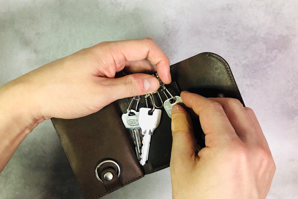 MC-keyiwallet。蔵前の革職人が製作した国産牛革のキーケース一体型ミニ財布。ダークブラウン。キーケースから鍵を取り出しているGIFアニメーション。