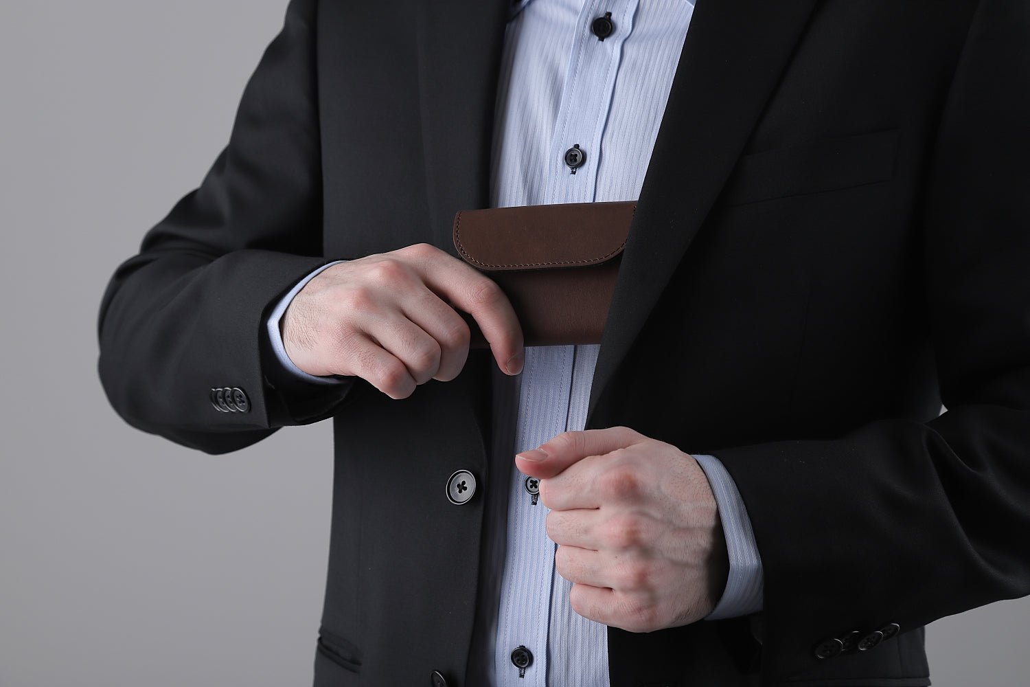 MC-keywallet。蔵前の革職人が製作した国産牛革のキーケース一体型ミニ財布。ダークブラウン。財布を胸ポケットにしまうシーン。