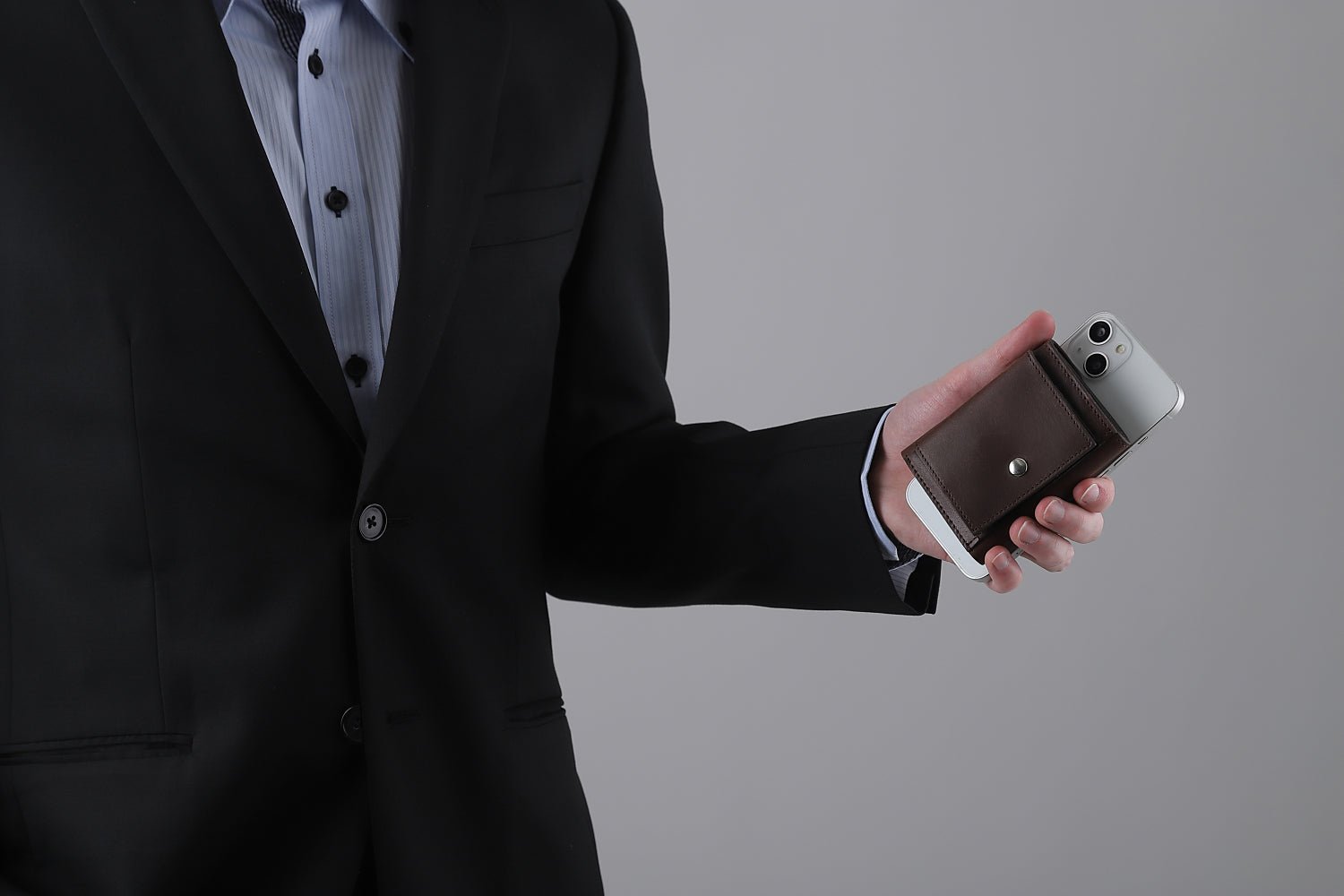 MC-keywallet。蔵前の革職人が製作した国産牛革のキーケース一体型ミニ財布。ダークブラウン。財布とスマホを持ち合わせしているシーン。