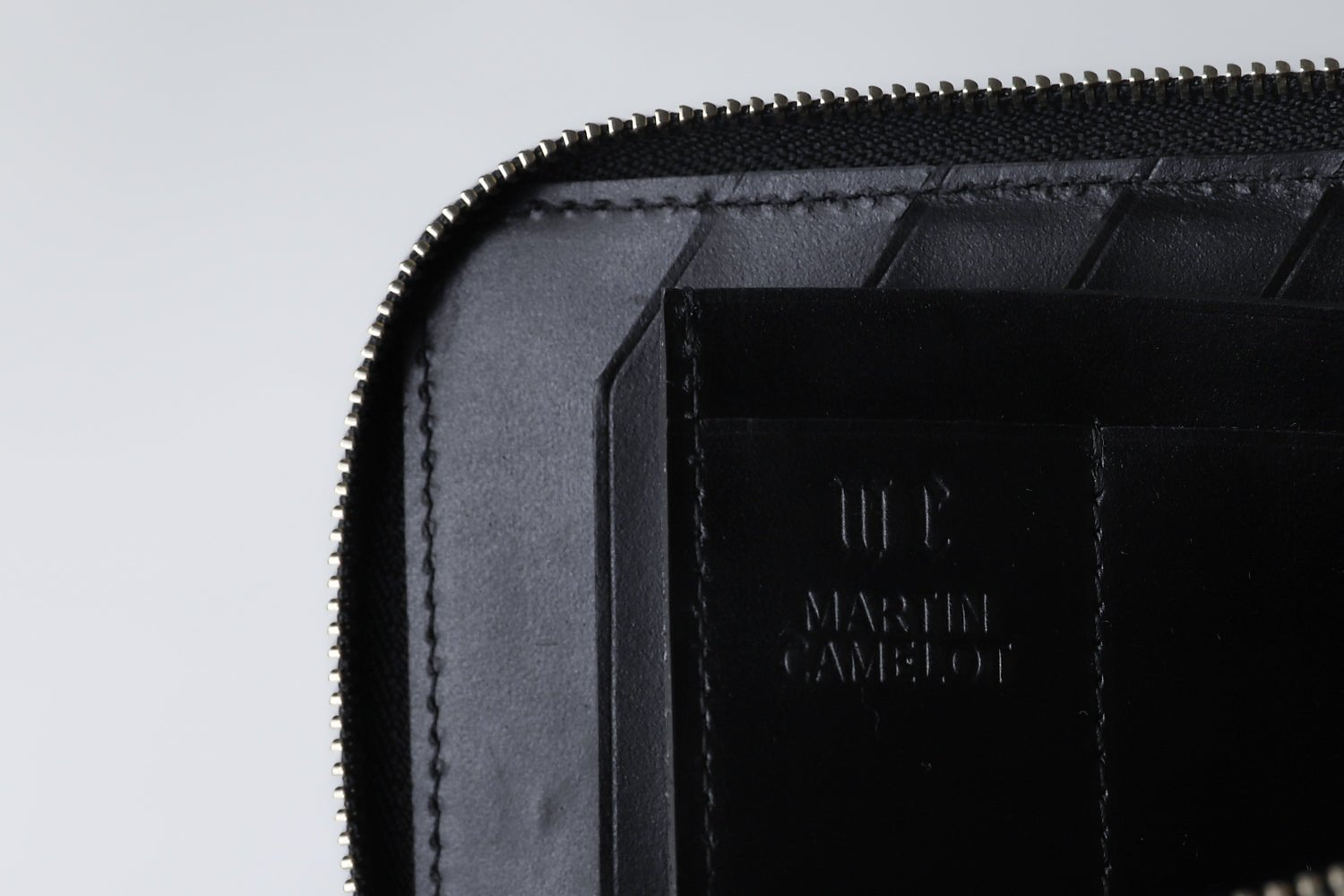 MC-longwallet。蔵前の革職人が製作した国産牛革のL字ファスナーコンパクト長財布。ブラック。ロゴのイメージ。