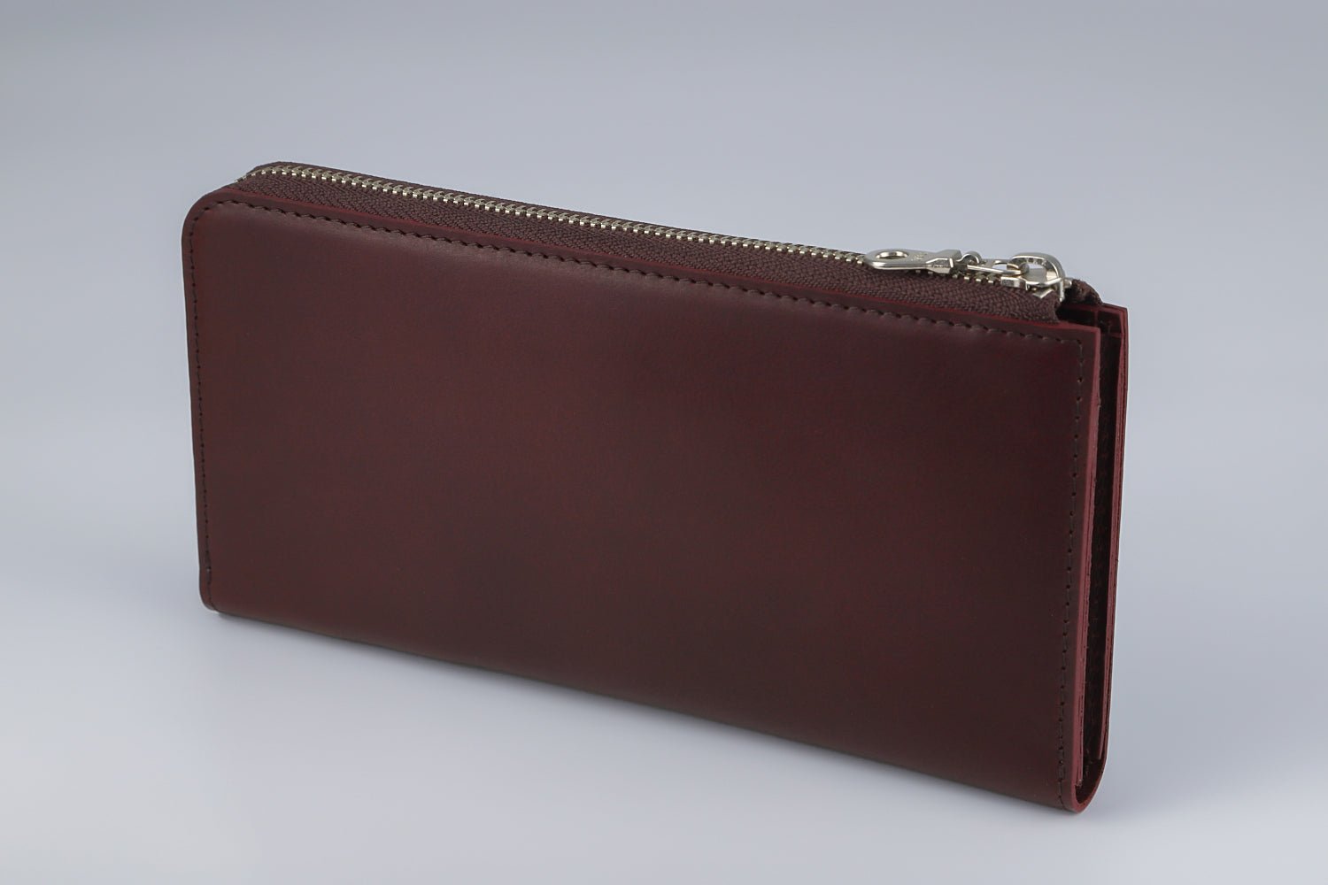 MC-longwallet。蔵前の革職人が製作した国産牛革のL字ファスナーコンパクト長財布。バーガンディ。斜めのイメージ。