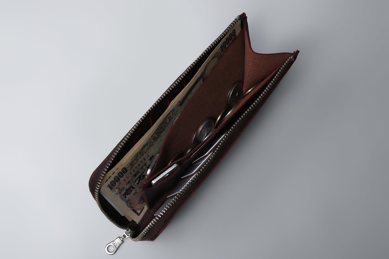 MC-longwallet。蔵前の革職人が製作した国産牛革のL字ファスナーコンパクト長財布。バーガンディ。紙幣、小銭、カード、鍵の収納イメージ。