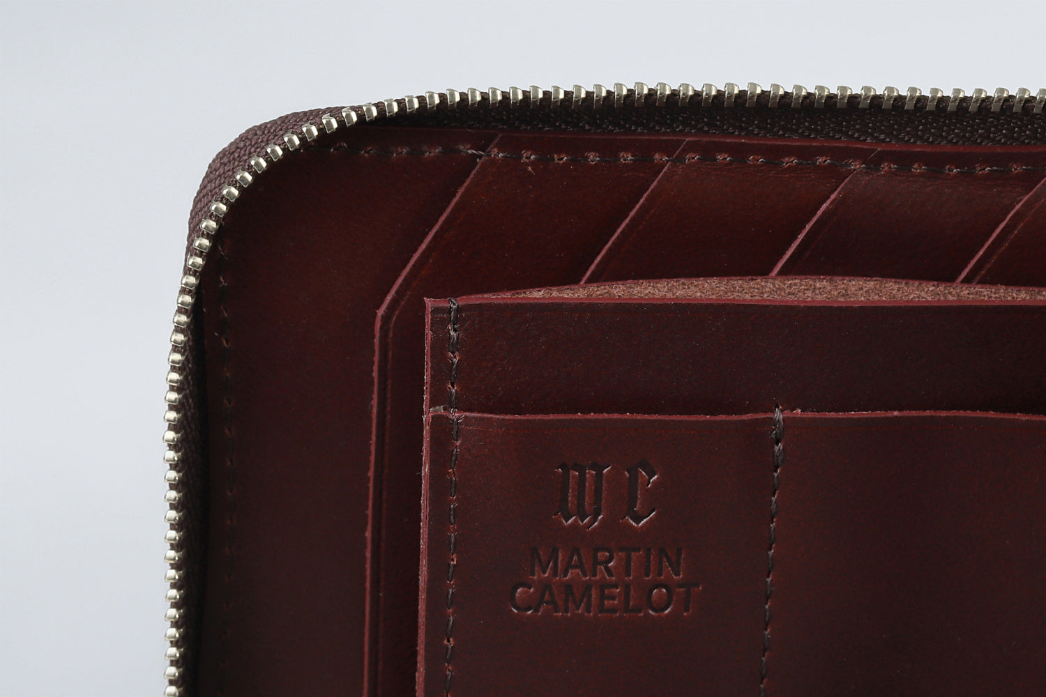MC-longwallet。蔵前の革職人が製作した国産牛革のL字ファスナーコンパクト長財布。バーガンディ。ロゴのイメージ。
