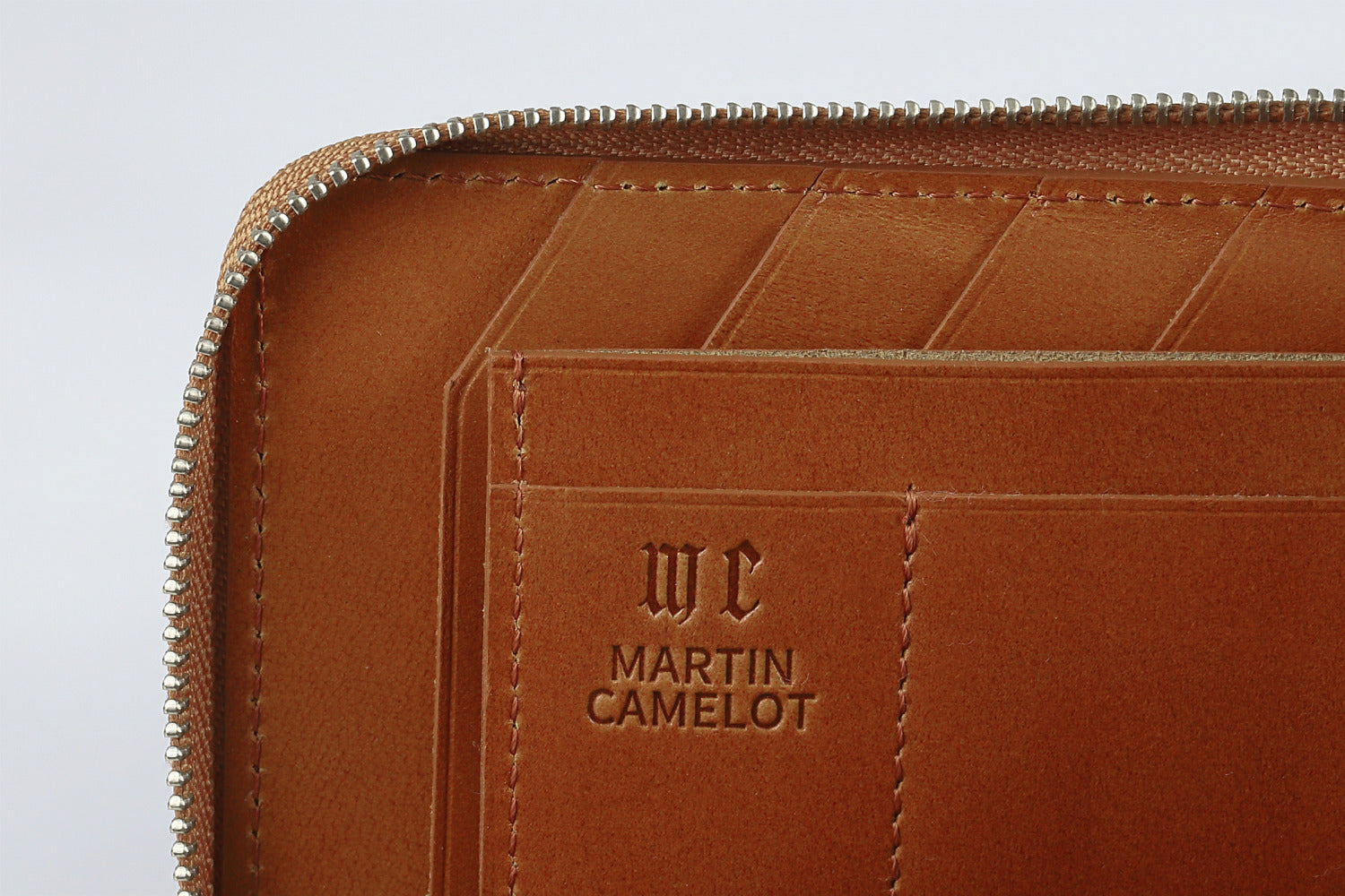 MC-longwallet。蔵前の革職人が製作した国産牛革のL字ファスナーコンパクト長財布。キャメル。ロゴのイメージ。