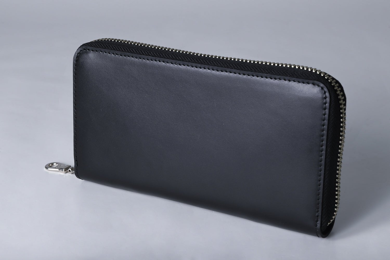 MC-longwallet2。蔵前の革職人が製作した国産牛革のラウンドファスナーコンパクト長財布。ブラック。斜めのイメージ。