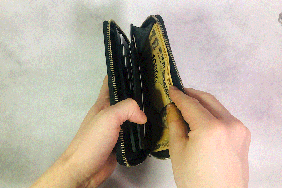 MC-longwallet2。蔵前の革職人が製作した国産牛革のラウンドファスナーコンパクト長財布。ブラック。紙幣を取り出しているGIFアニメーション。