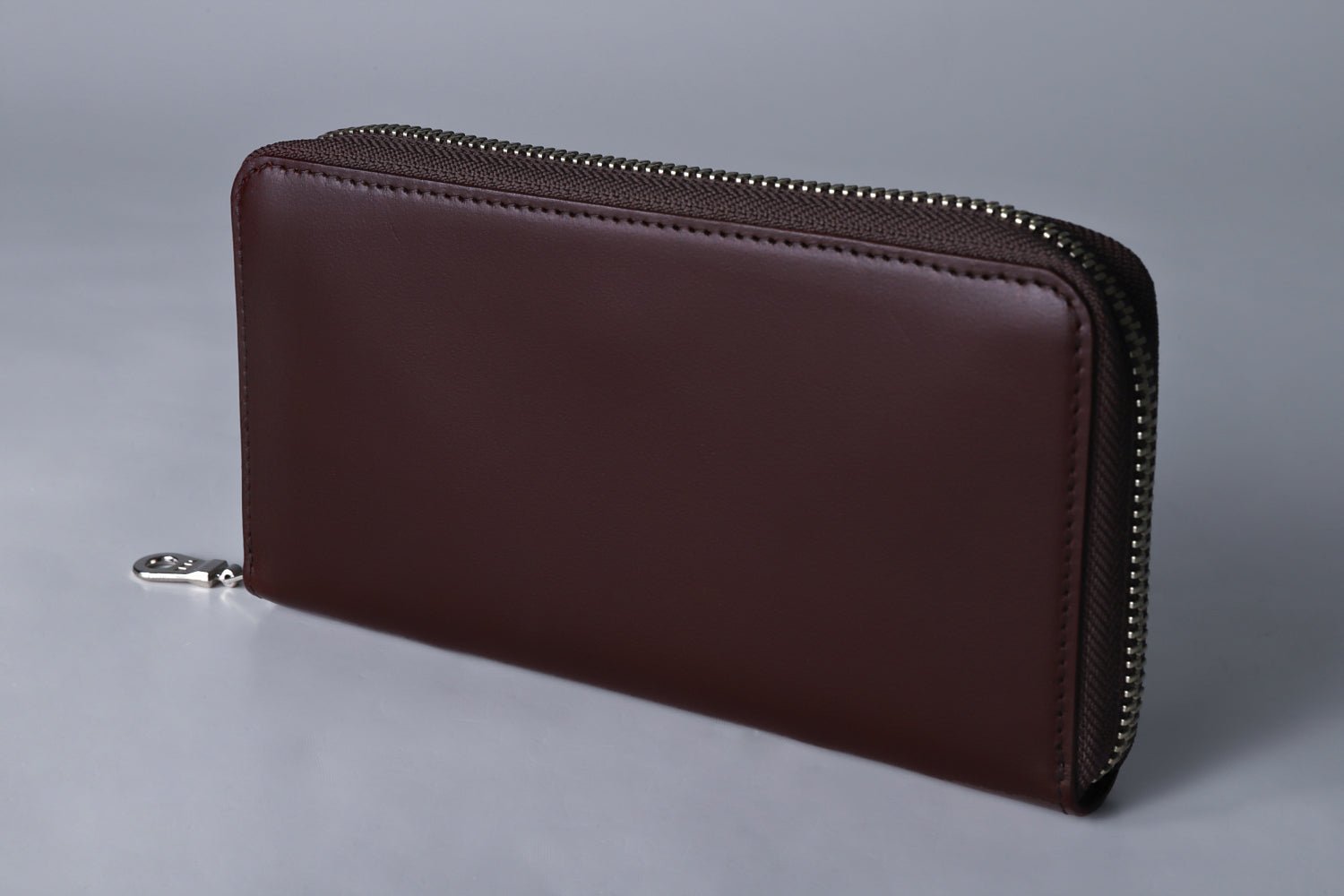 MC-longwallet2。蔵前の革職人が製作した国産牛革のラウンドファスナーコンパクト長財布。バーガンディ。斜めのイメージ。