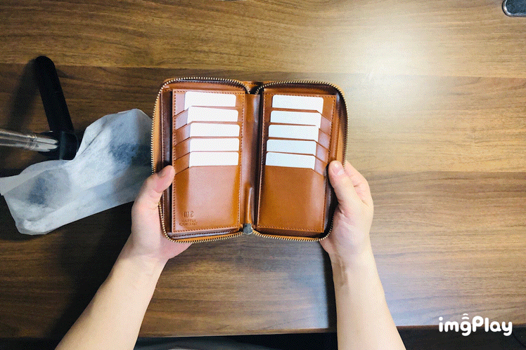 MC-longwallet2。蔵前の革職人が製作した国産牛革のラウンドファスナーミニマル長財布。キャメル。カードホルダーからカードを取り出しているGIFアニメーション。