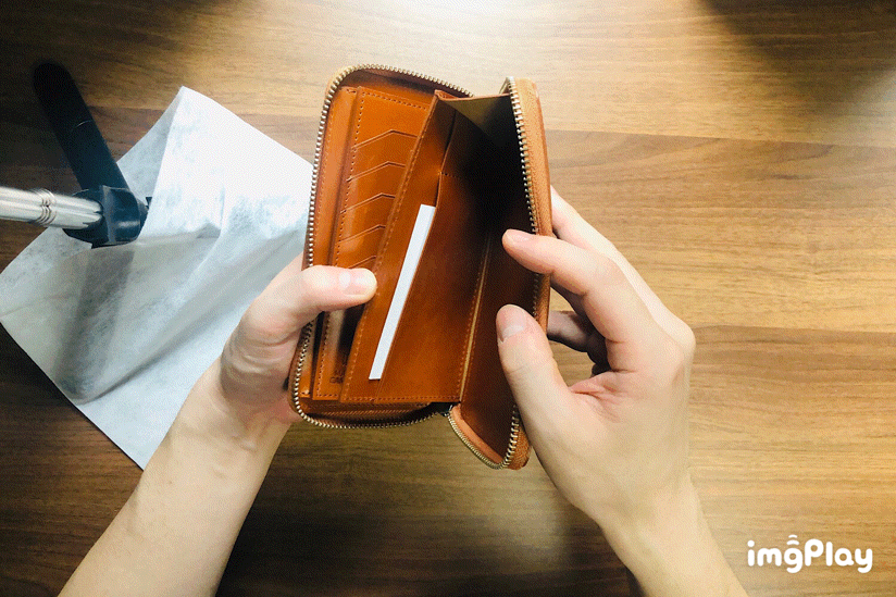 MC-longwallet2。蔵前の革職人が製作した国産牛革のラウンドファスナーミニマル長財布。キャメル。フリーポケットからカードを取り出しているGIFアニメーション。