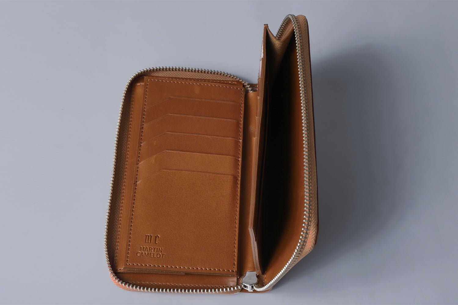 MC-longwallet2。蔵前の革職人が製作した国産牛革のラウンドファスナーコンパクト長財布。キャメル。紙幣スペースも見える開いたイメージ。