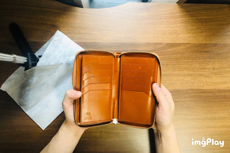 MC-longwallet2。蔵前の革職人が製作した国産牛革のラウンドファスナーミニマル長財布。キャメル。小銭を取り出しているGIFアニメーション。
