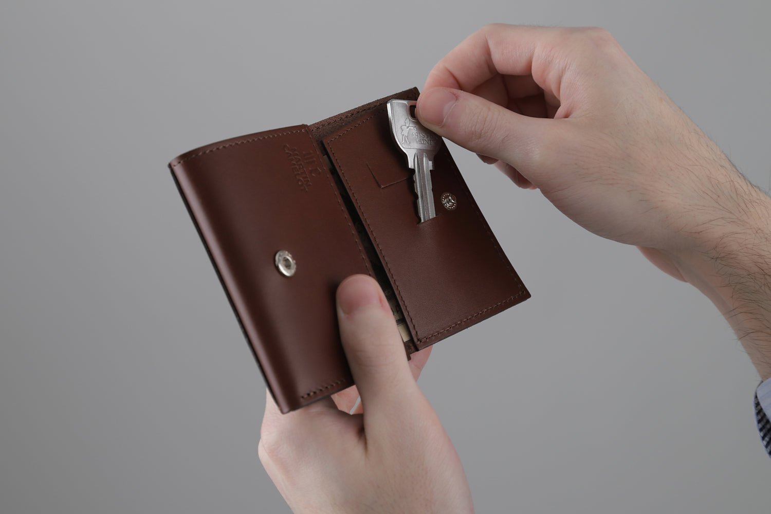 MC-miniwallet。蔵前の革職人が製作した国産牛革のミニ財布。ブラウン。鍵を取り出しているイメージ。