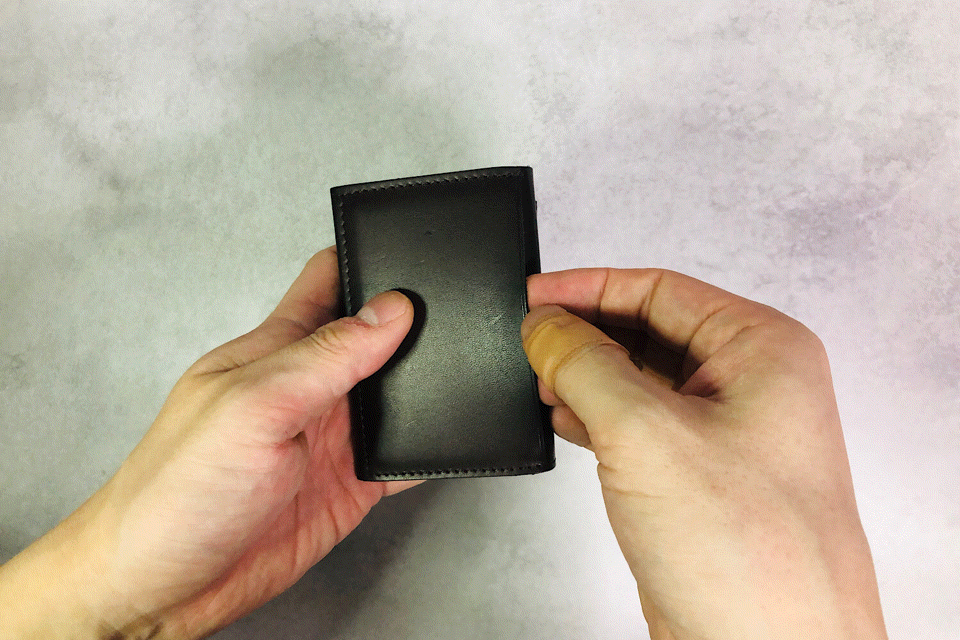 MC-miniwallet。蔵前の革職人が製作した国産牛革のミニ財布。ダークブラウン。裏面ポケットからカードを取り出しているGIFアニメーション。