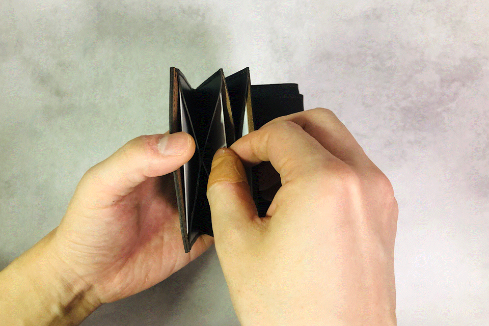 MC-miniwallet。蔵前の革職人が製作した国産牛革のミニ財布。ダークブラウン。カードホルダーからカードを取り出しているGIFアニメーション。