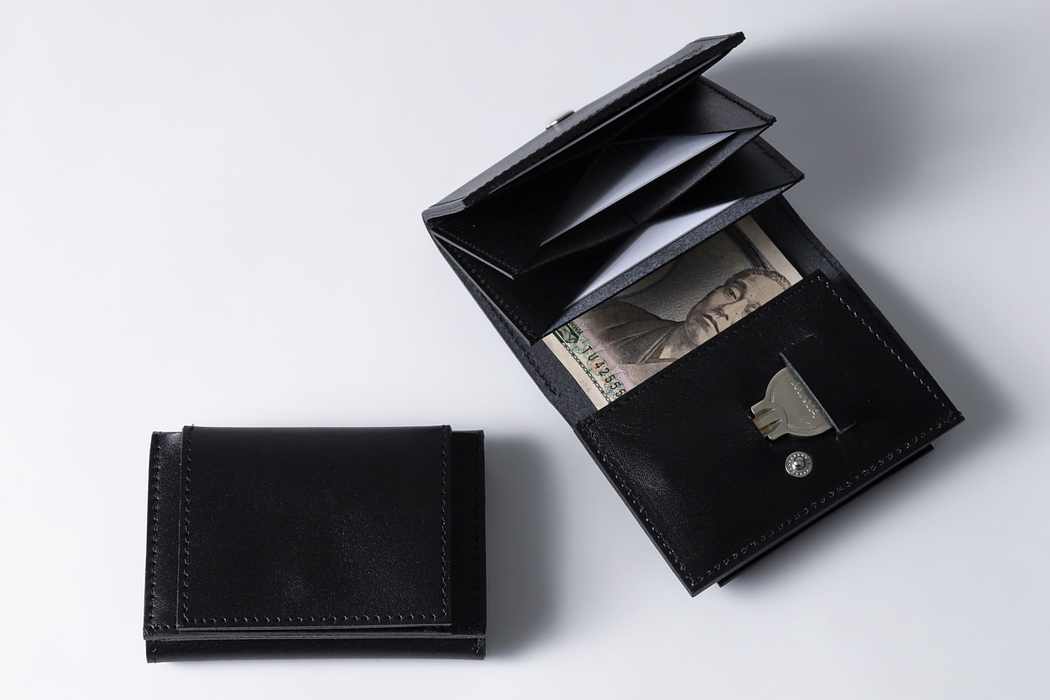 MC-miniwallet。蔵前の革職人が製作した国産牛革のミニ財布。ブラック。紙幣、カード、鍵の収納イメージ。コインBOXが閉じた状態。