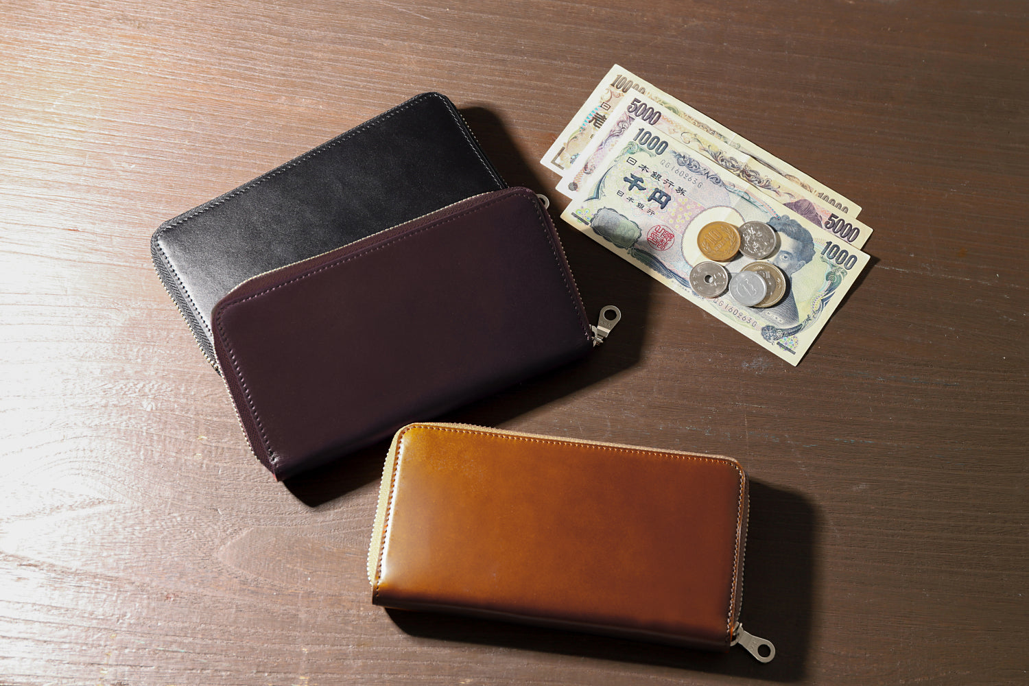 MC-longwallet2。蔵前の革職人が製作した国産牛革のラウンドファスナーミニマル長財布。ブラック、バーガンディ、キャメルの3色。アンティークな空間のイメージカット。