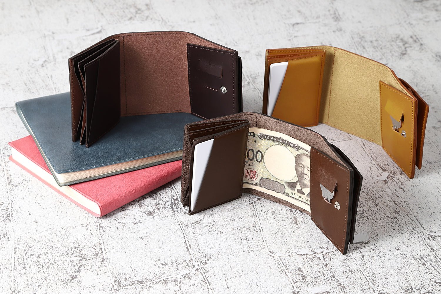 MC-miniwallet。蔵前の革職人が製作した国産牛革のミニ財布。キャメル、ブラウン、ダークブラウンの3色。紙幣、カード、鍵を収納した見開きイメージ。