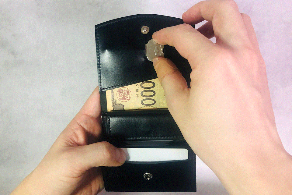 MC-bifoldwallet。蔵前の革職人が製作した国産牛革の薄いコンパクト二つ折り財布。ブラック。鍵を取り出しているGIFアニメーション。