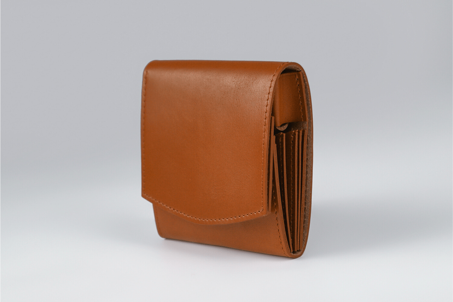 MC-bifoldwallet。蔵前の革職人が製作した国産牛革の薄いコンパクト二つ折り財布。キャメル。斜めのイメージ。