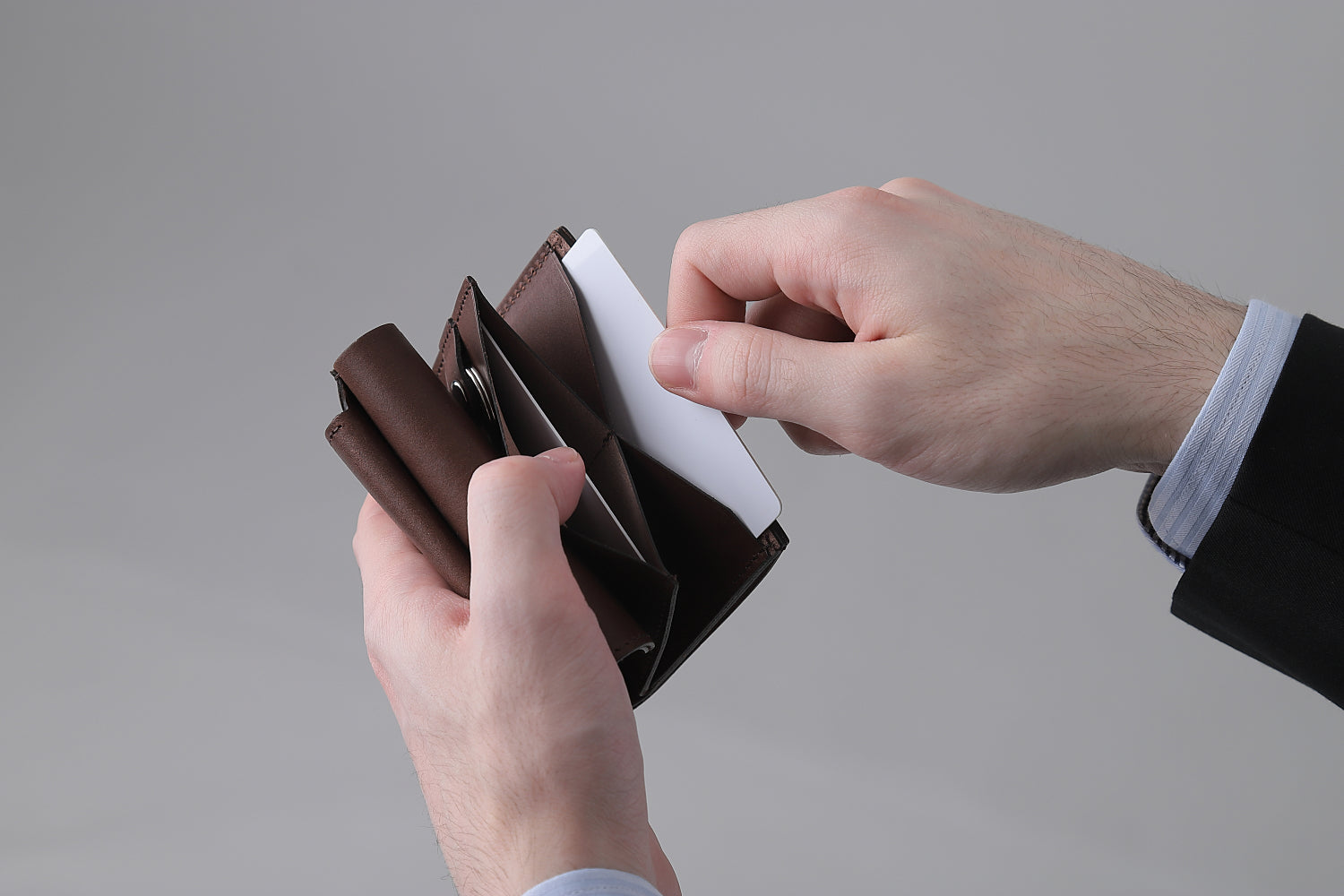 MC-keyminimal。蔵前の革職人が製作した国産牛革のキーケース一体型ミニマル財布。ダークブラウン。カードホルダーからカードを取り出しているイメージ。
