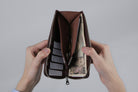 MC-longwallet。蔵前の革職人が製作した国産牛革のL字ファスナーミニマル長財布。バーガンディ。紙幣、小銭、カード、鍵を収納し、手で財布を見開いているシーン。